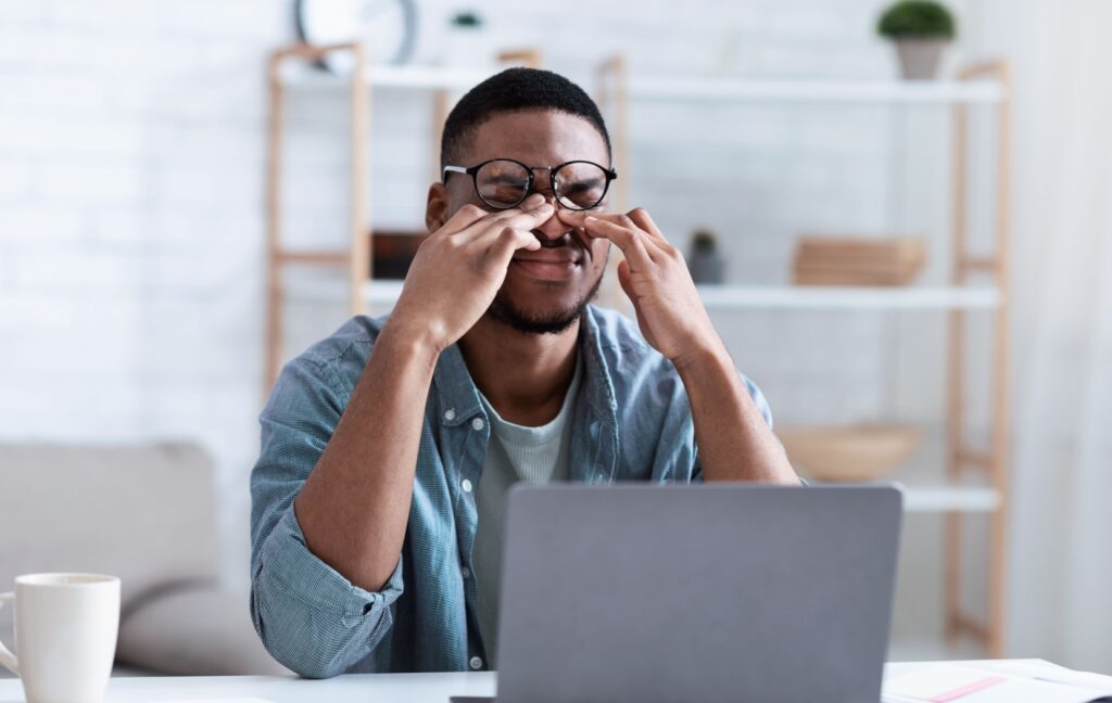 A person with dry eye rubs their eyes, frustrated with the lack of relief that traditional treatments bring them.